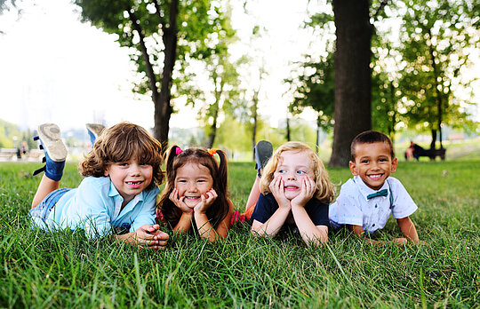 friends of preschool kids playing lying on the grass in the Park on a summer day friends of preschool kids playing lying on the grass in the Park on a summer day