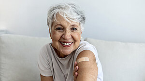 Portrait of a senior woman proudly showing her arm with bandage after getting vaccine.