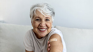 Portrait of a senior woman proudly showing her arm with bandage after getting vaccine.