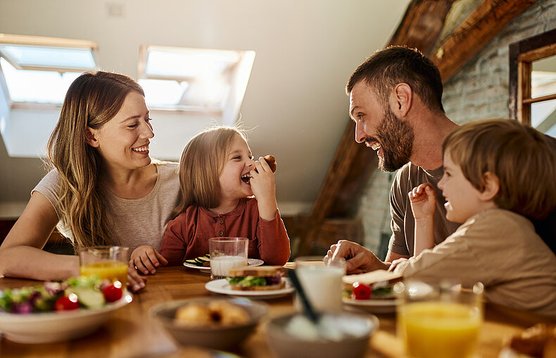 Young family talking during breakfast at dining table. afbeelding Contact