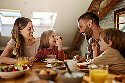 Familie van vader, moeder, dochter en zoon aan de eettafel aan het eten